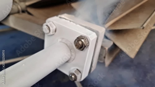 Sidoarjo, Indonesia - 26 June, 2026: Industrial Pipe Flange Leak: Freezing Vapor and Steam Escaping from Frosted Metal Joint Connection in Manufacturing Plant