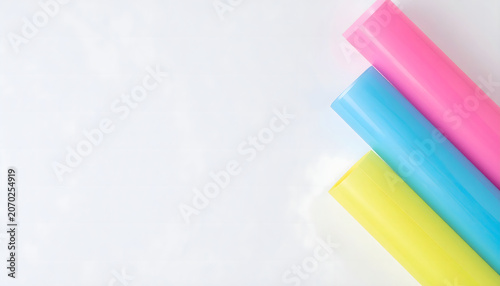 Colorful translucent paper rolls on minimalist white background