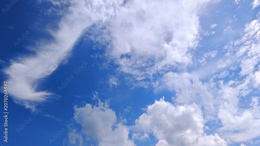 Fototapeta premium Vivid Blue Sky with Wispy and Fluffy Clouds