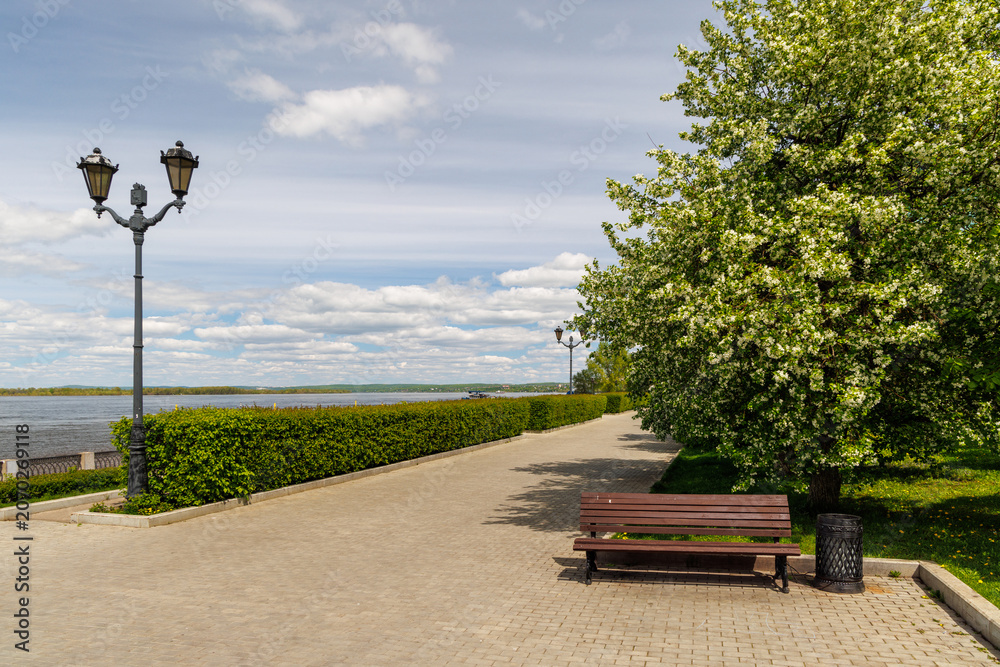 Fototapeta premium Bench on waterfront promenade with river view