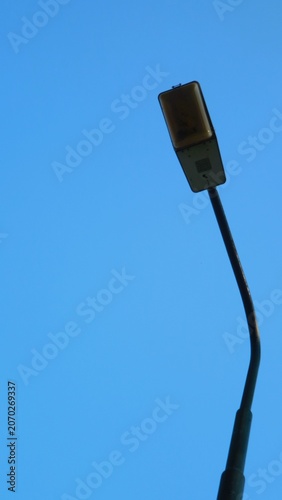 Close-up shot of a sleek, modern street light against a clear blue sky