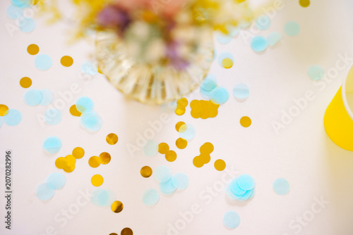 Golden and blue paper confetti on a party table macro