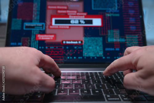 Εκτύπωση καμβά Hacker types on a laptop keyboard and starts an illegal download of sensitive data, computer crime