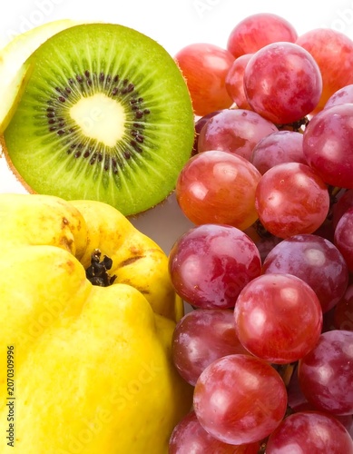 Fresh Sliced Kiwi and Red Grape Cluster with Yellow Quince on White Background