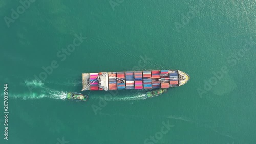Expansive container ship navigates teal ocean under dark sky, transporting global cargo via modern freighter and support vessel-serene maritime trade scene for business or industry applications.
