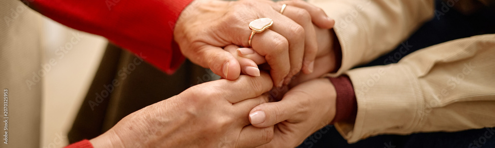 Fototapeta premium Website header shot of adult women holding hands, showing comfort, empathy, support during difficult conversation, close up. Ideal for counseling, caregiving, mental health, trust messaging