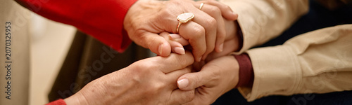 Fotografi Website header shot of adult women holding hands, showing comfort, empathy, support during difficult conversation, close up