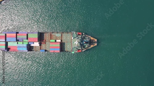 Large container ship traverses dark blue ocean filled with vibrant containers, symbolizing global trade and efficient international shipping amidst calm seas and substantial freight transport.
