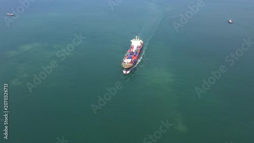 Large container ship navigates dark blue ocean under expansive overcast sky, showcasing global trade and maritime transport across vast seascape for logistics solutions.