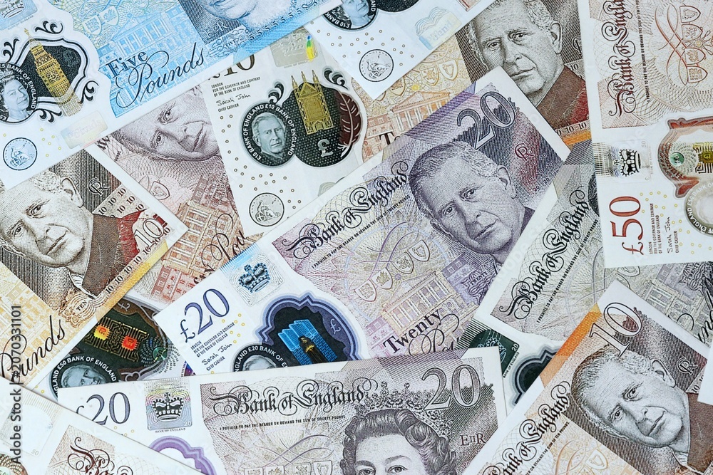 Obraz premium British pound money bills in pile on table. United Kingdom GBP currency cash