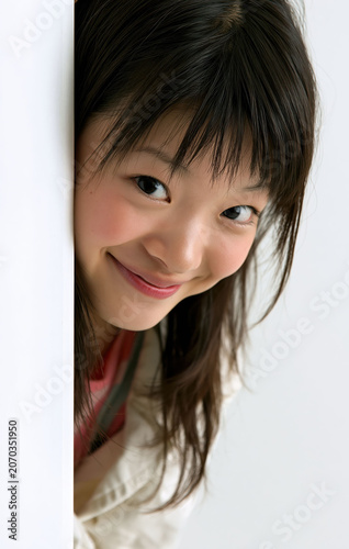 Woman smiling while holding a clean white vertical panel for branding and advertising use in a minimal white studio setting.