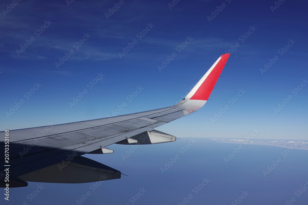 Fototapeta premium A view from the airplane window showing a blue sky; a concept of air transport for tourism.