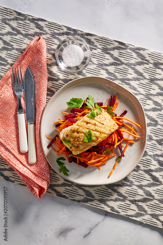 pan seared fish on a bed of red cabbage, and shredded carrot