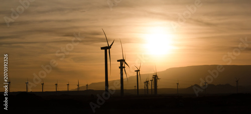 Wind Turbines Silhouetted Against Golden Sunset Sky
