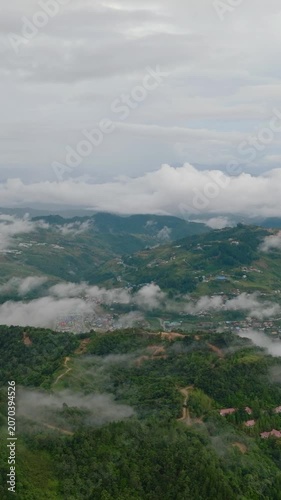 Mountain landscape with green hills and farmland. Borneo, Sabah, Malaysia. Vertical video.