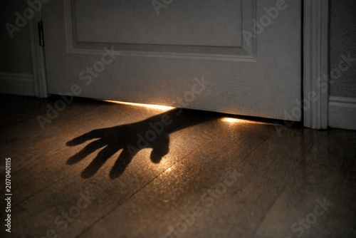 A shadowy hand emerges from a doorway, creating a sense of mystery and intrigue