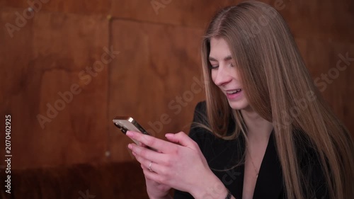 Young businesswoman smiling while using smartphone