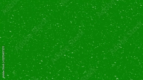 White snowflakes, winter snow particles falling gracefully on green screen. small snow flakes over dark background, falling snowflakes, and snowfall for christmas and holiday design, 4k video