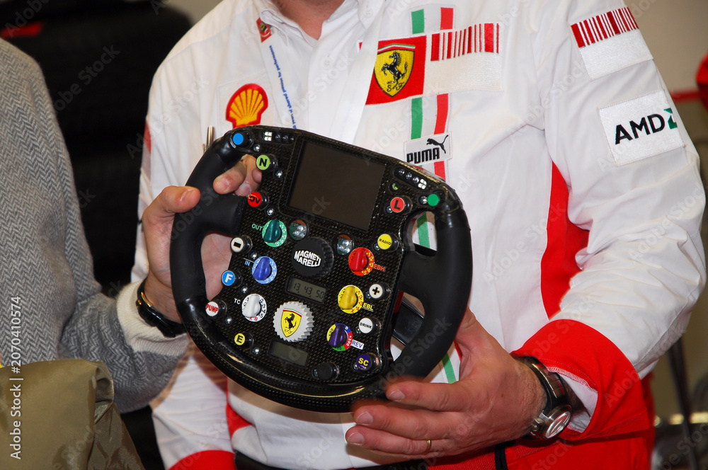 Naklejka premium Mugello, Italy - November 28, 2007: An unknown man holds a modern Formula 1 steering wheel during the 2007 Ferrari World Finals.