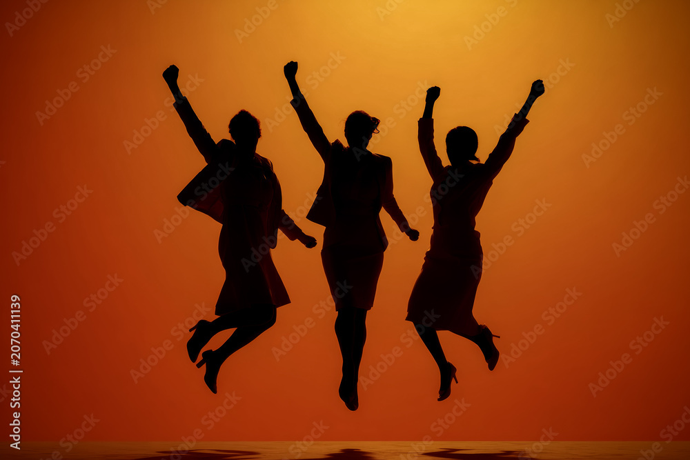 Fototapeta premium Work Life Joy, Colleagues jump outdoors under warm sunlight, reflecting work-life balance, joy, and a healthy lifestyle.