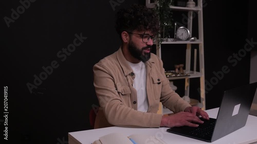 Focused male freelancer typing on laptop computer at desk