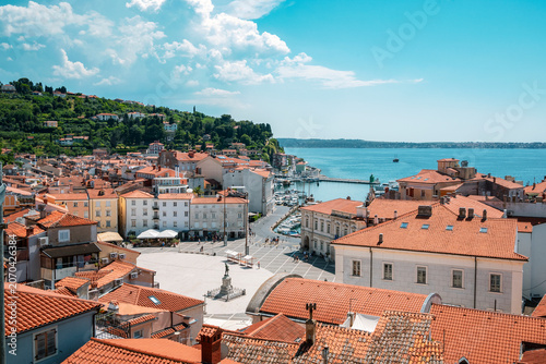 Panoramic view of Piran, Slovenia, with Tartini Square, marina and Adriatic coast under blue summer sky