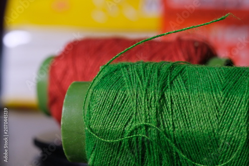 Картината върху платно Close-up of red and green sewing thread spools with selective focus, perfect for