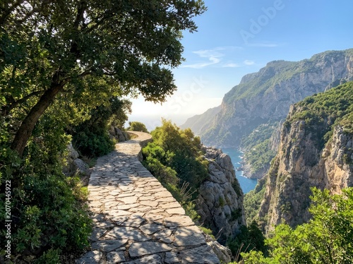 Stone path along a cliff edge, scenic coastal landscape with sea view.