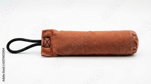 Brown canvas dog training dummy with black handle on white