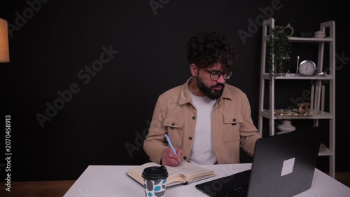 Young man working on laptop and drinking coffee