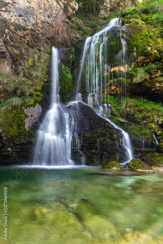 Long exposure of beautiful cascading Virje Waterfall in green nature, Slovenia, Europe