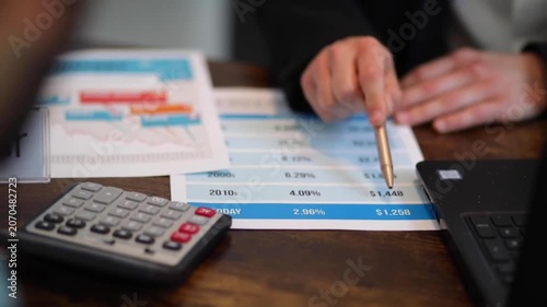 Team analyzing statistical financial data tables on printed documents finance table business statistics analysis