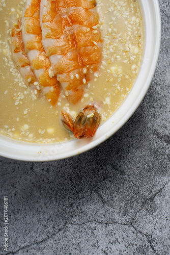 Miso soup with shrimp in a bowl, top view.