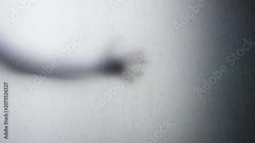 Blurred Human Hand Reaching Through Frosted Glass Against a Grainy Translucent Surface. Mysterious Presence, Fear, Suspense and Psychological Tension