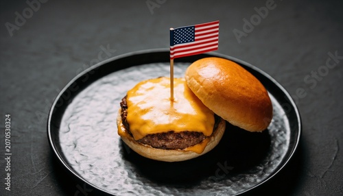 Gourmet cheeseburger with small American flag on black plate