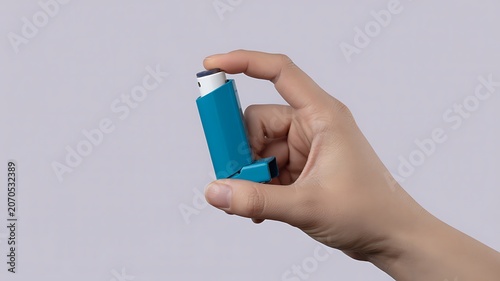 Asthma inhaler, blue medication, hand holding, healthcare device, respiratory treatment