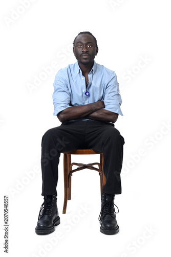 front view of a man sitting on chair looking at camera and arms crossed  on white background