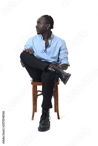front view of a man sitting on chair looking away and cross legged  on white background