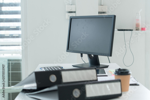 Young Businesswoman Working at Office Desk While Managing Documents and Mobile Communication.