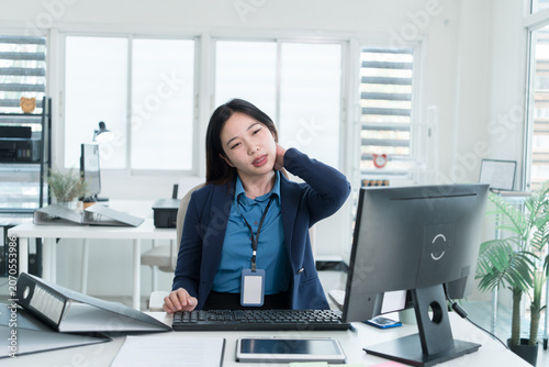 Young Businesswoman Working at Office Desk While Managing Documents and Mobile Communication.