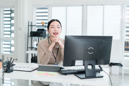 Young Businesswoman Working at Office Desk While Managing Documents and Mobile Communication.