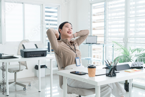 Young Businesswoman Working at Office Desk While Managing Documents and Mobile Communication.