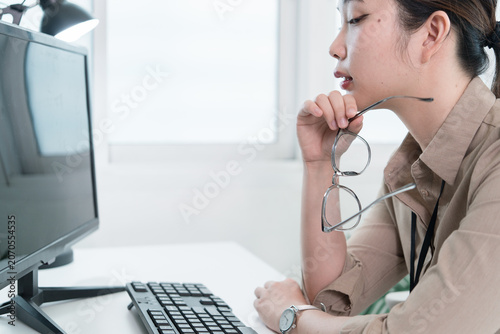 Young Businesswoman Working at Office Desk While Managing Documents and Mobile Communication.