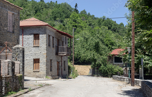 Abandoned village with stone houses and a road (Evrytania, Central Greece) close-up
