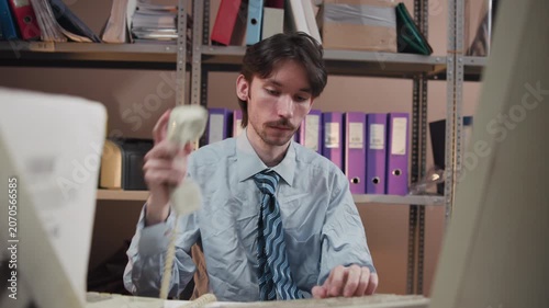Office worker typing at desk in archive room