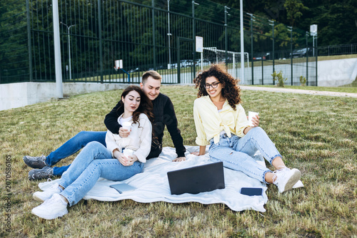Students relaxing outdoor on campus with laptop