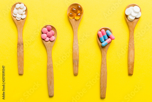 Bild auf Leinwand Vitamin capsules in a spoon on a colored background