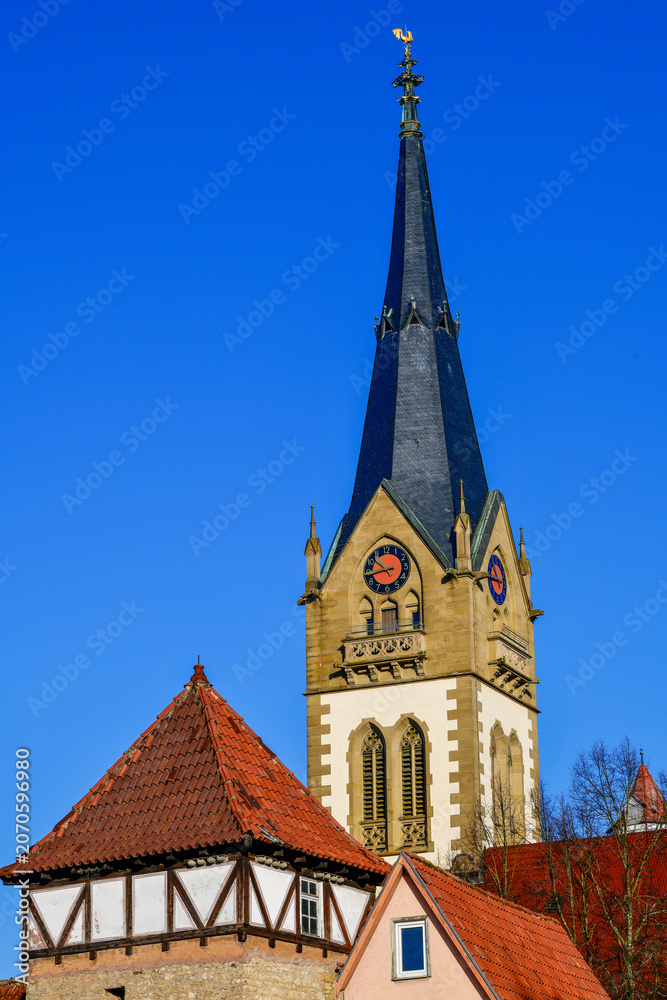 Obraz premium Der markante neugotische Turm der Evangelischen Stadtkirche über den Dächern der Altstadt von Möckmühl, Baden-Württemberg