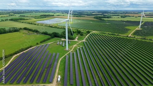 Aerial view of Chelveston Renewable Energy Park combining co-located solar panel arrays and wind turbines in Northamptonshire, UK.