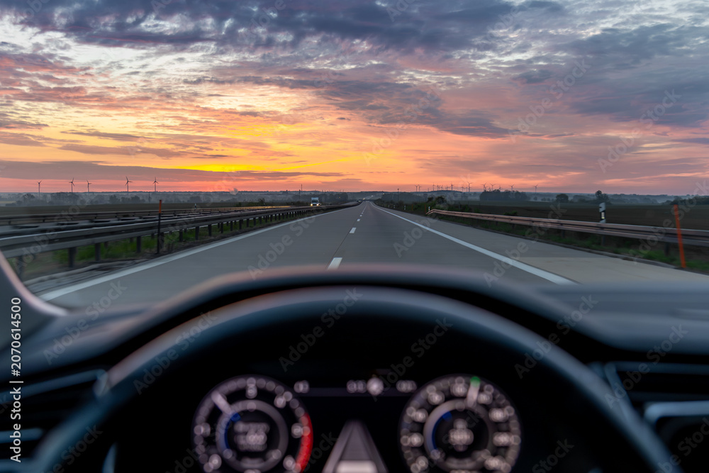 Fototapeta premium Highway view from car at sunset. Road travel and transport content.